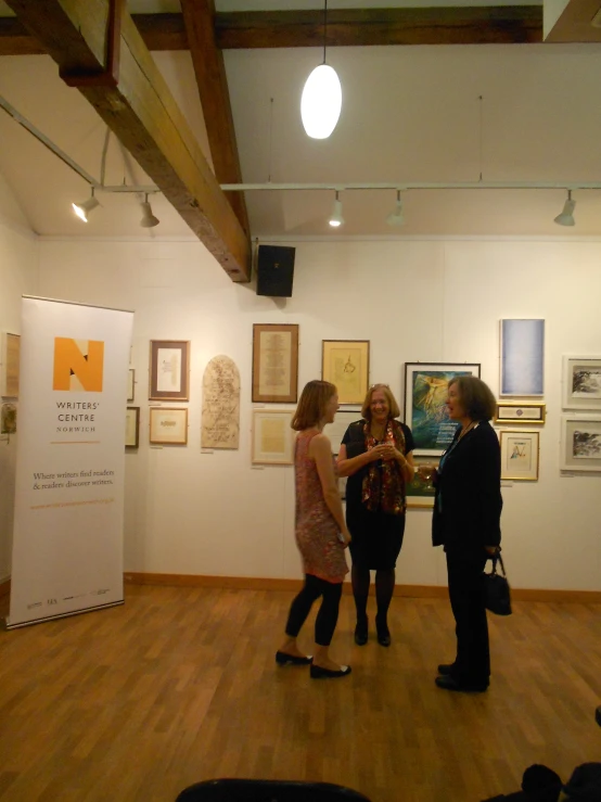 people standing in an art gallery viewing artwork