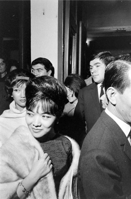 black and white pograph of a woman with fur coat in crowd