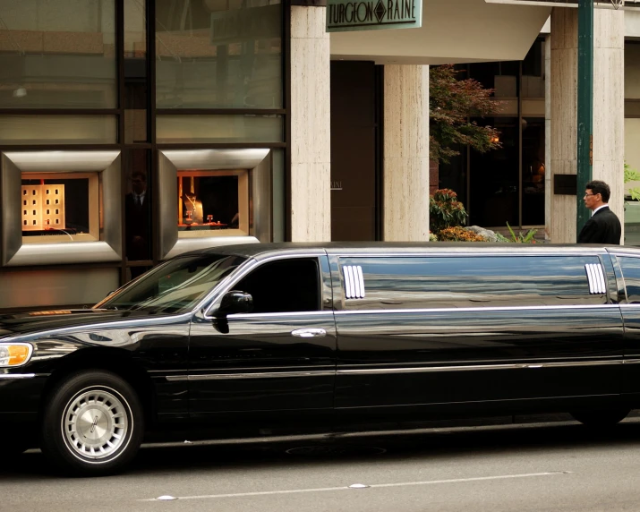 a limo parked in front of a el in the city