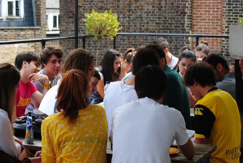 several young people gathered at an outside table