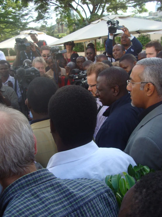 a group of men are standing around the camera man