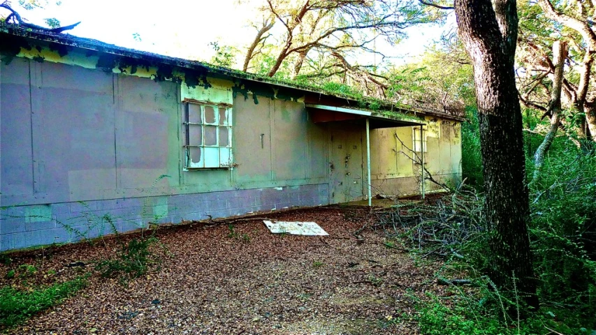 the side of a run down house with boarded doors