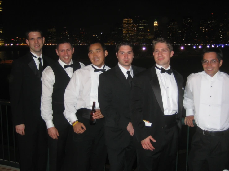 a group of men in tuxedos pose for a pograph