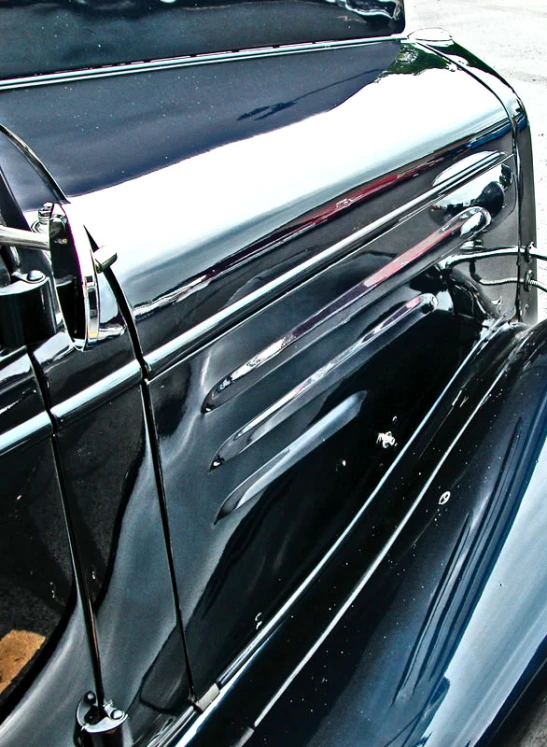 the back end of a classic car that has been painted black