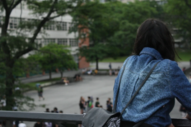 a lady looking out at people walking on the street from outside