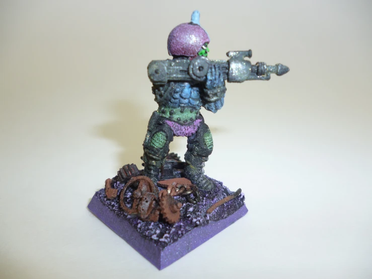 the small figurine is standing on a purple base