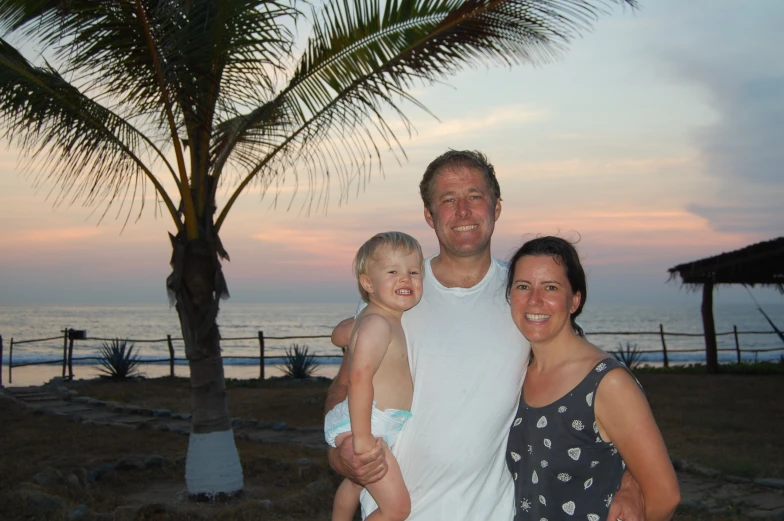 a family is posing for a po in front of the ocean