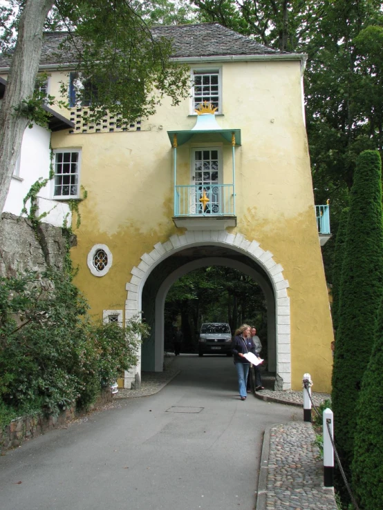 two people are under an arched doorway in front of a house