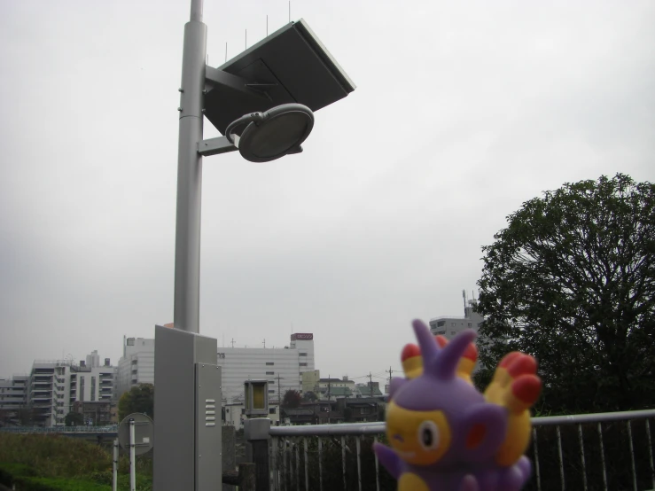 a street light on the sidewalk with a small figurine underneath it