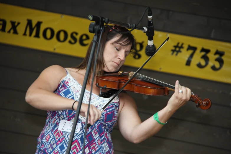 a woman holding a violin at an outdoor music festival