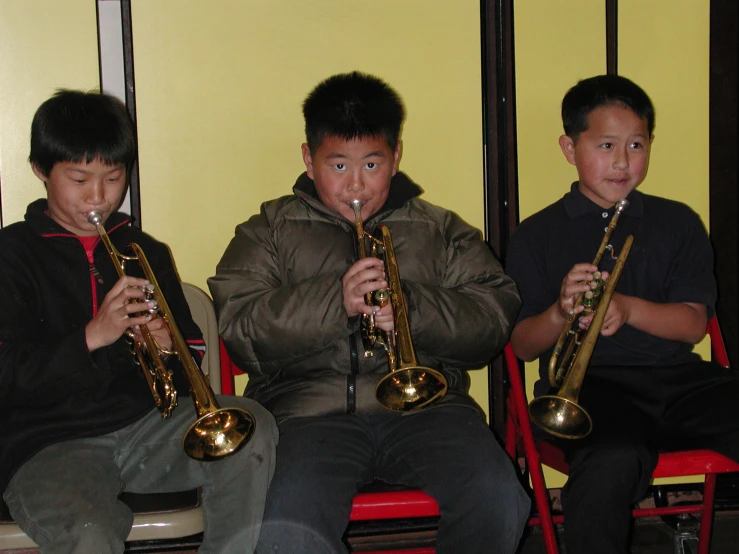 the young musicians play their musical instruments in a group