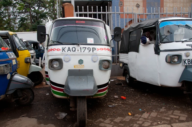 many different types of cars are parked on the side of the road