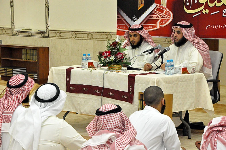 some men are sitting at a table talking