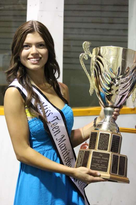 the young woman is holding her trophy and posing for a po