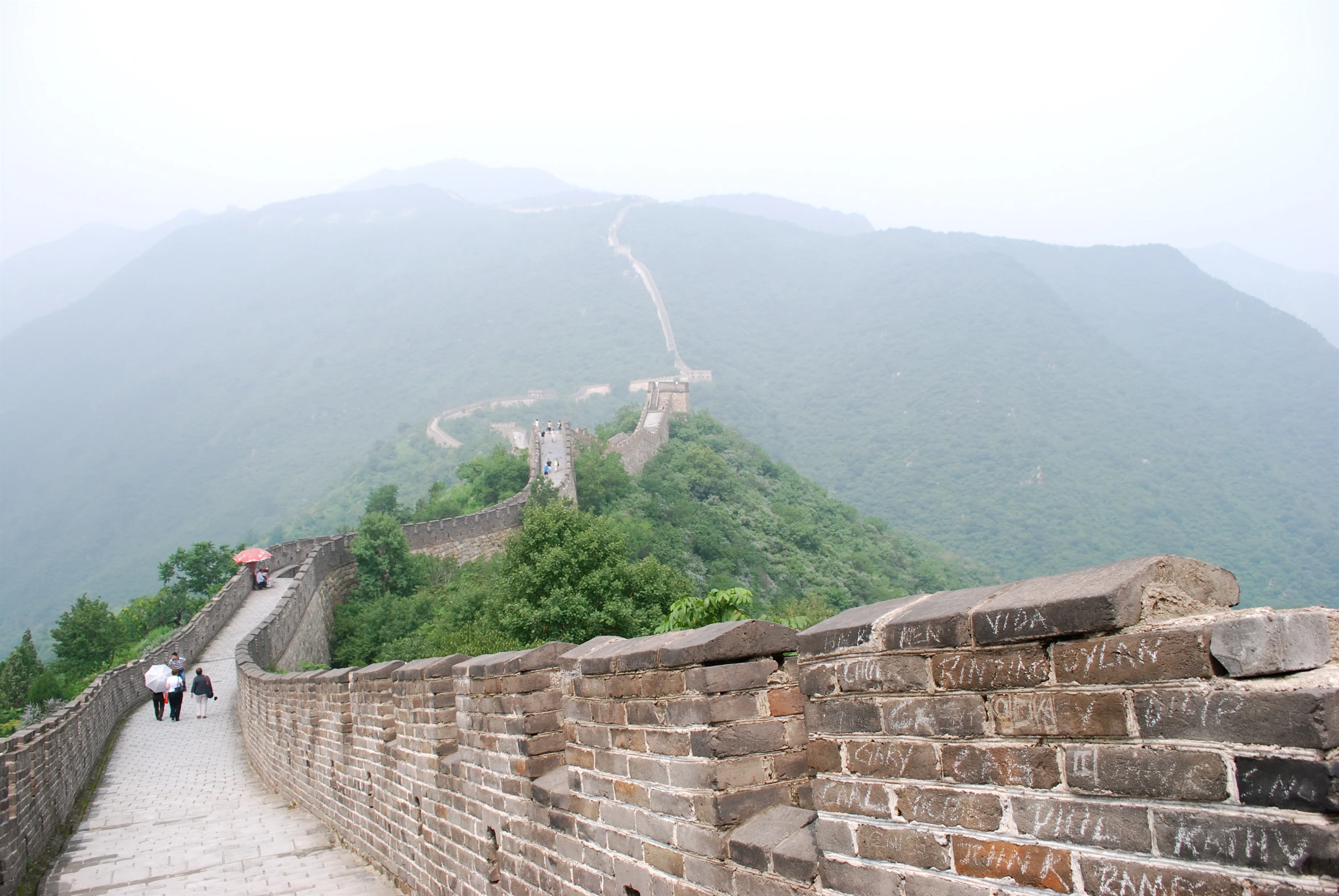 the view of a very long wall with mountains in the back