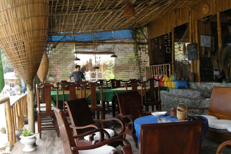 a group of wooden chairs sitting under a hut