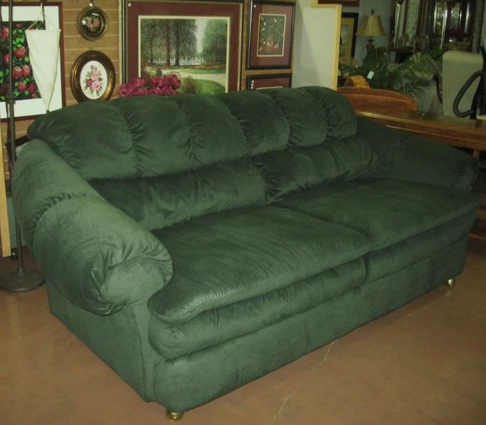 a green love seat couch on display in a room