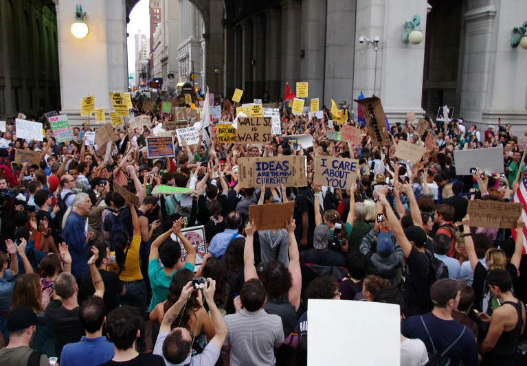 a large crowd of people gather outside to protest