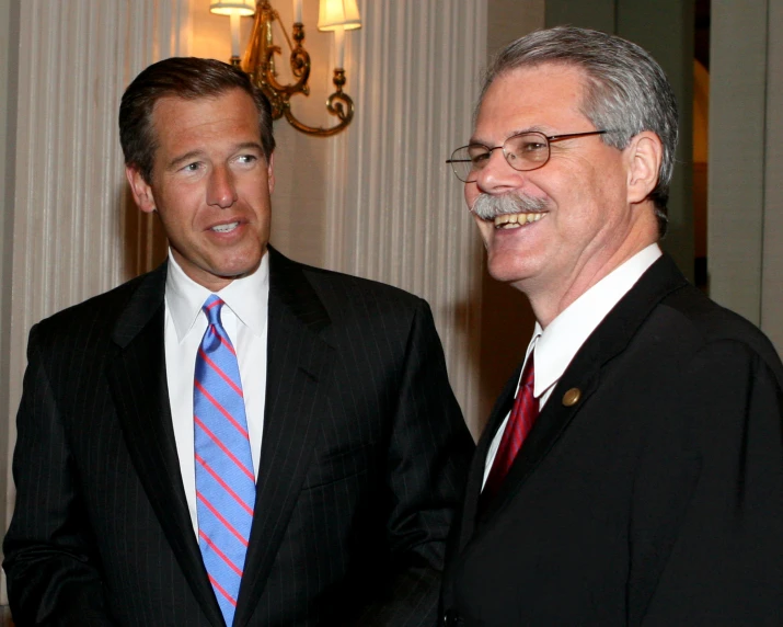 two men in suits and ties standing next to each other