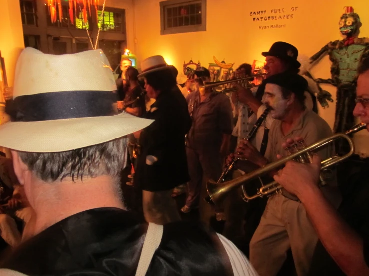 men in white hats are playing trumpet instruments at a party