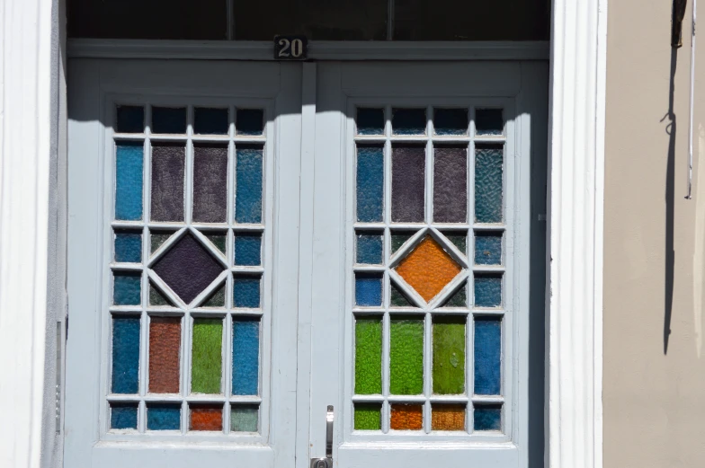 two doors with colored glass in each and one with the number 20