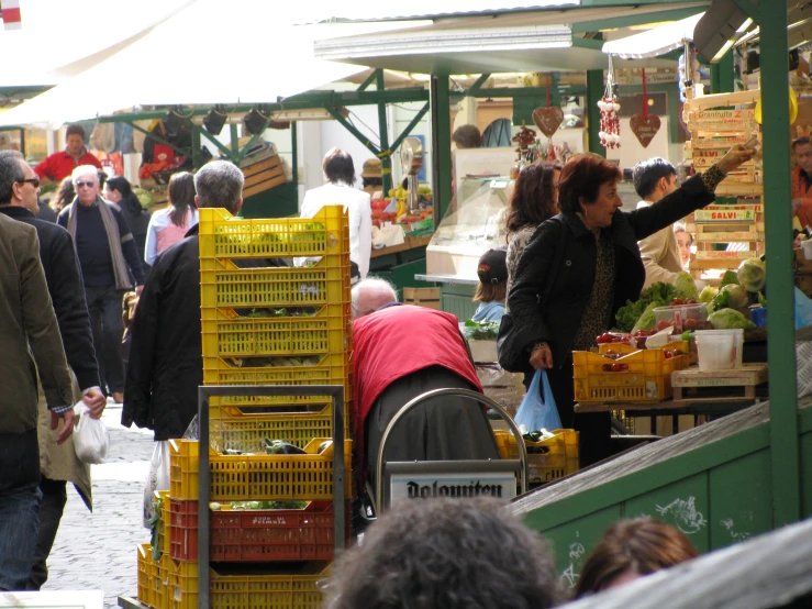 many people are shopping at an outdoor farmers market