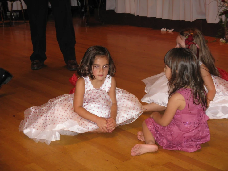 two s sitting on the floor in white dresses