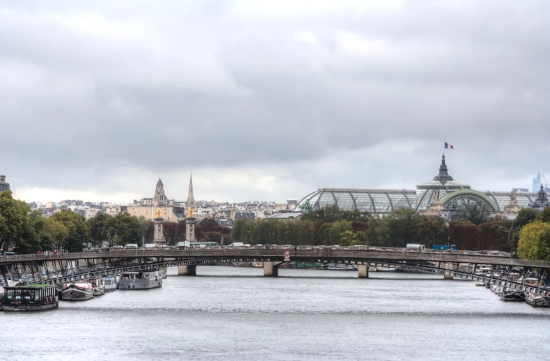 the bridge across the river leads to buildings and trees