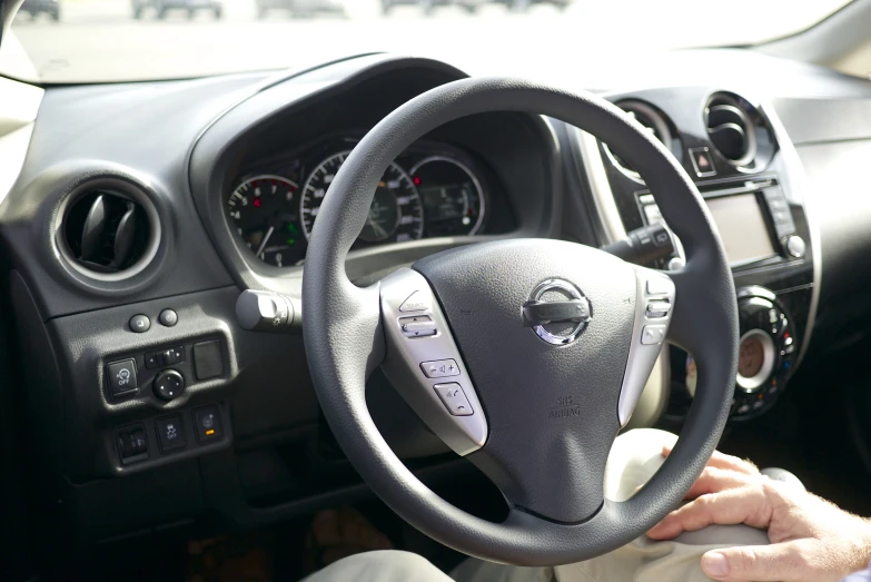 a man driving in his vehicle looking at the dashboard and radio