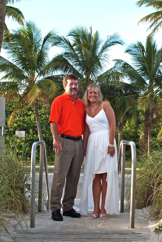 a couple poses for a picture while standing on a set of steps