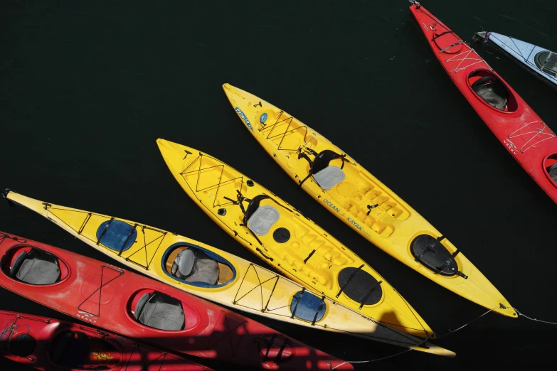 three kayaks and three paddles laying on the water