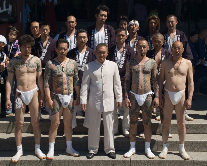 some shirtless men are posing with other men