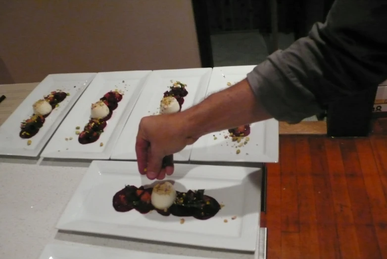 a man is slicing up food on square plates