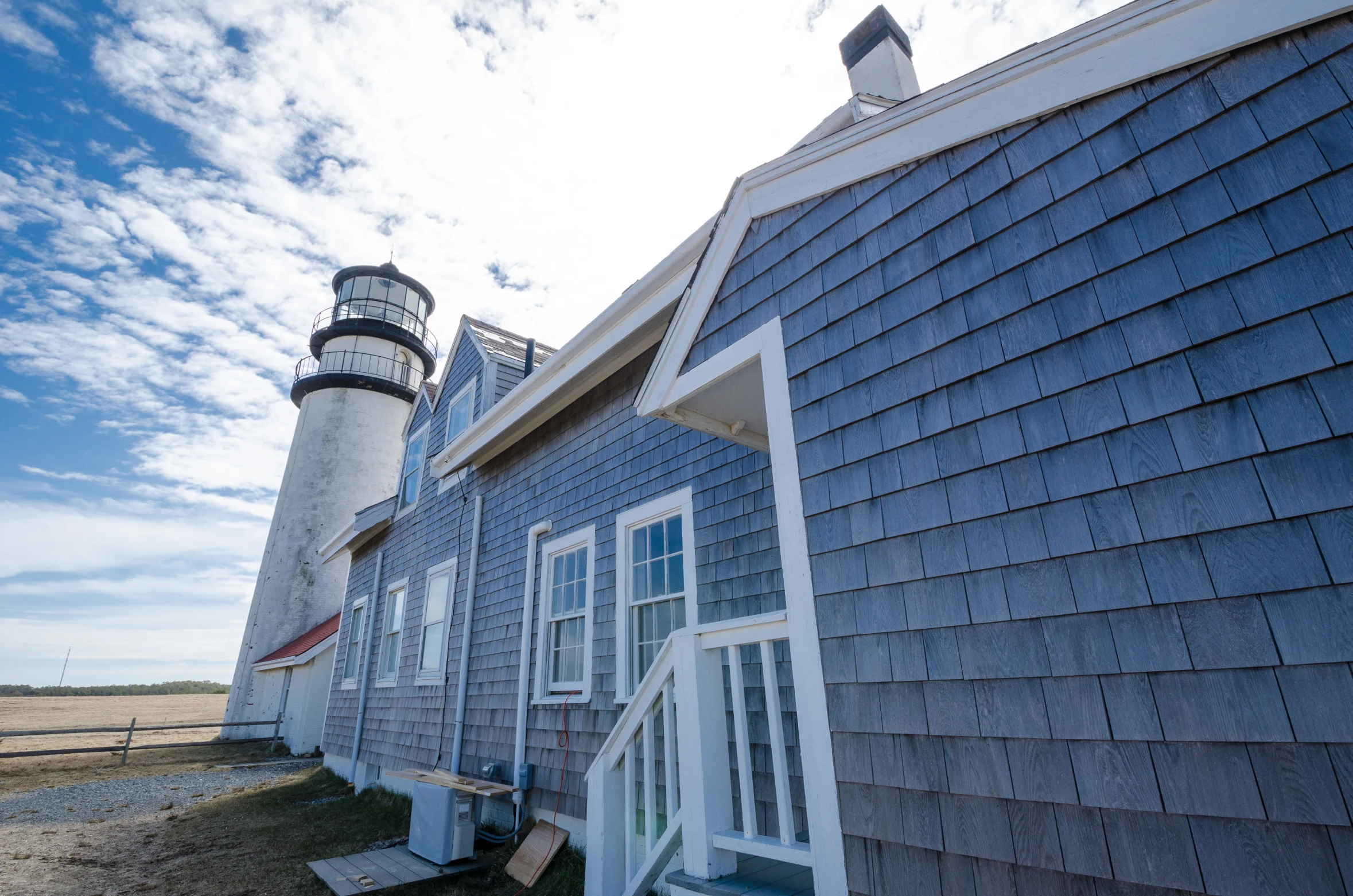 a house with a light house behind it