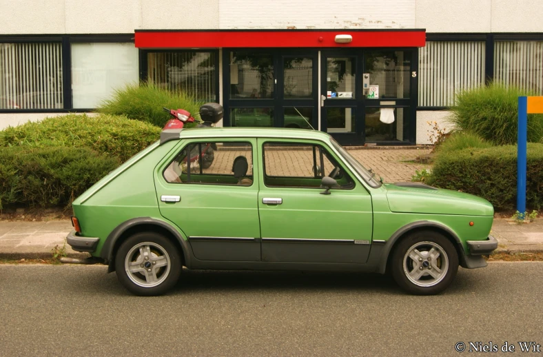 a green car parked in front of a building