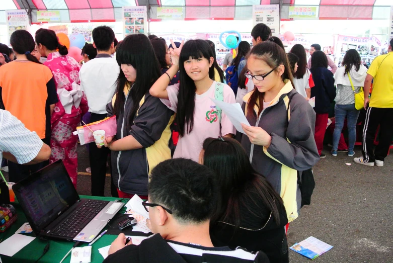 people standing around in line with laptops at a convention