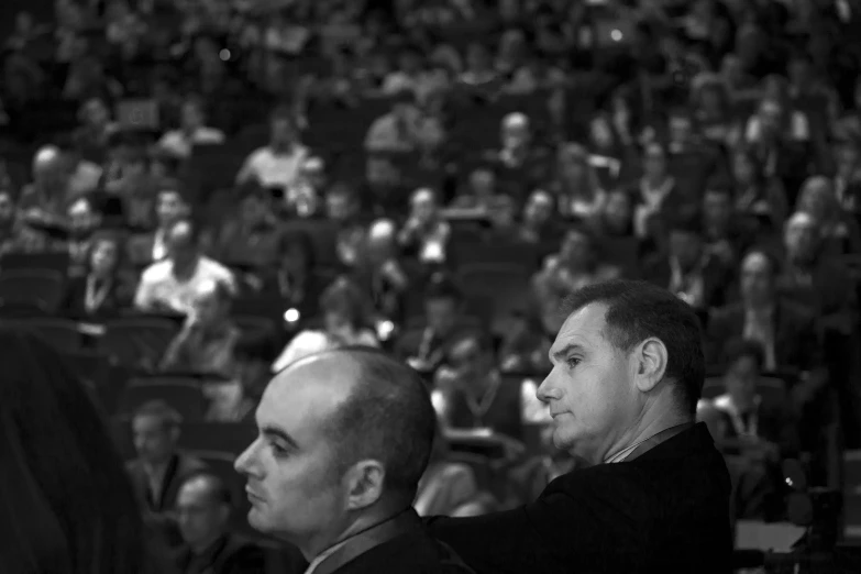 a black and white po of two men in a conference hall