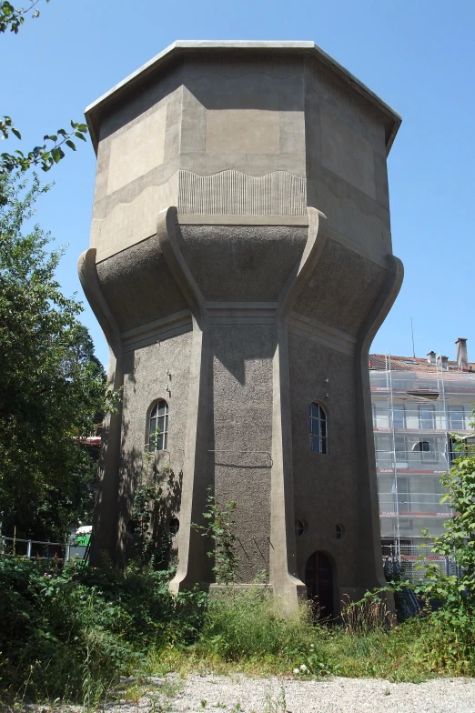 a very tall clock tower next to some bushes