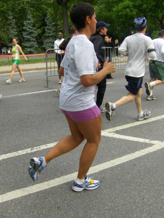 a young woman runs along the street while others run