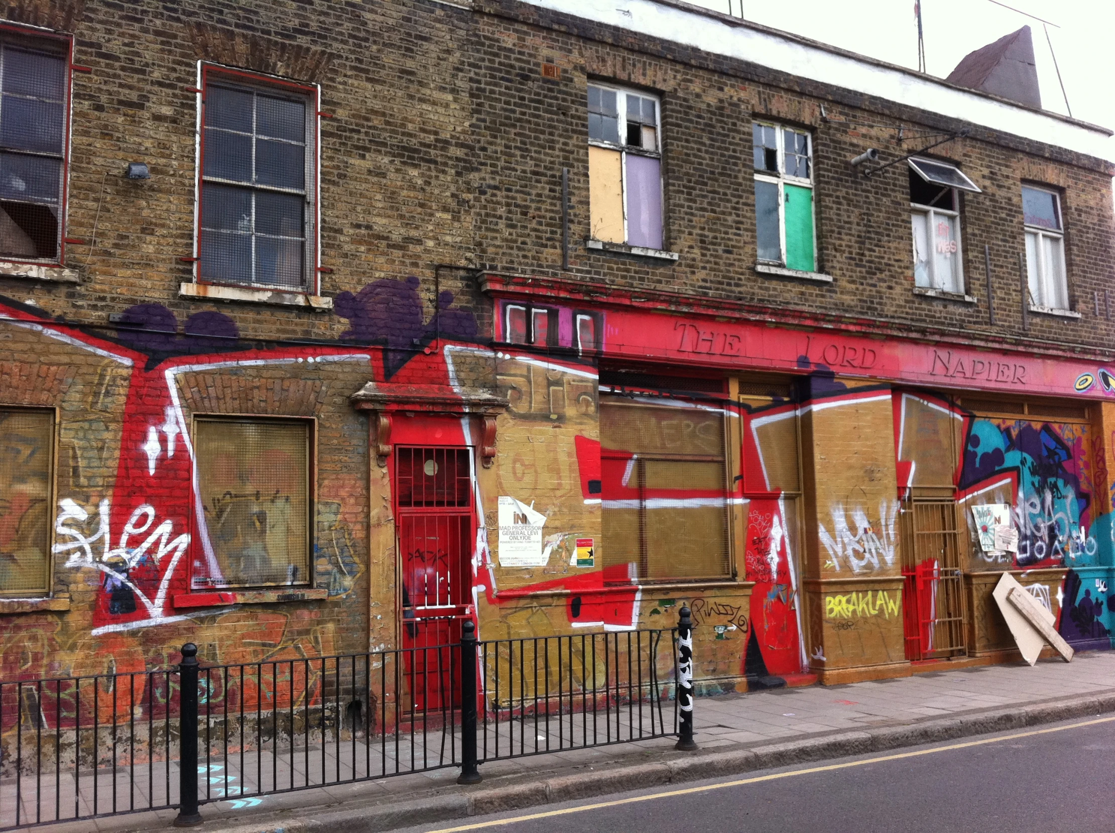 graffiti in a brick building with fenced area and large windows