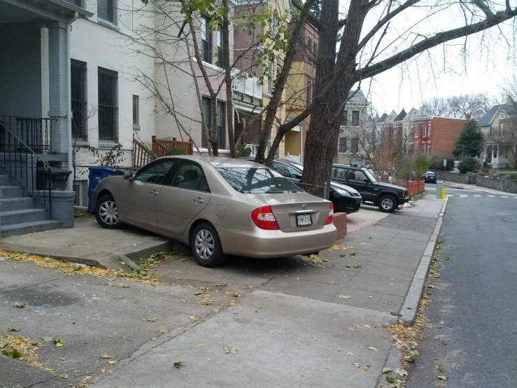 several parked cars on the sidewalk of a residential area