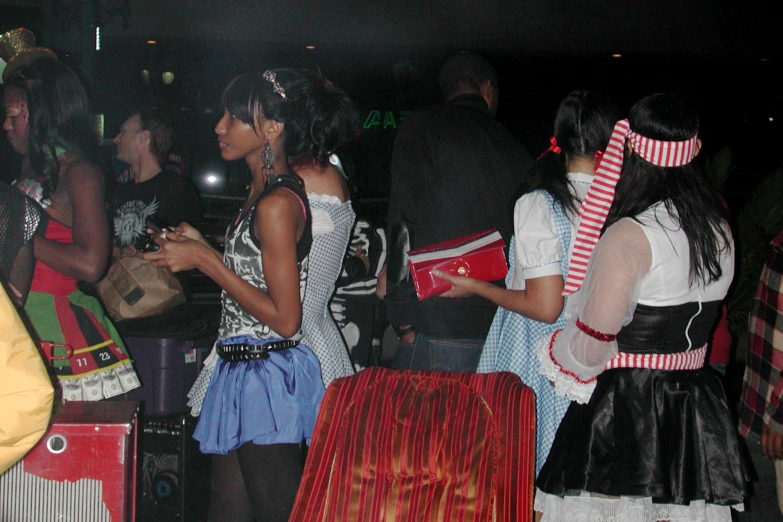 many people in costumes standing around with bags and backpacks