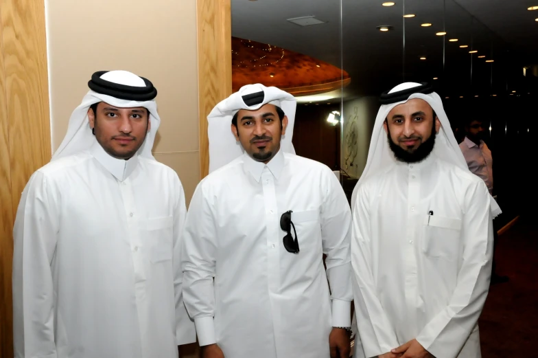 a group of three men in white dress clothes