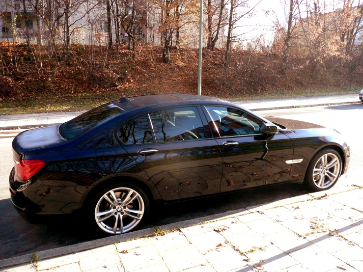 a bmw sits parked at the curb next to the street