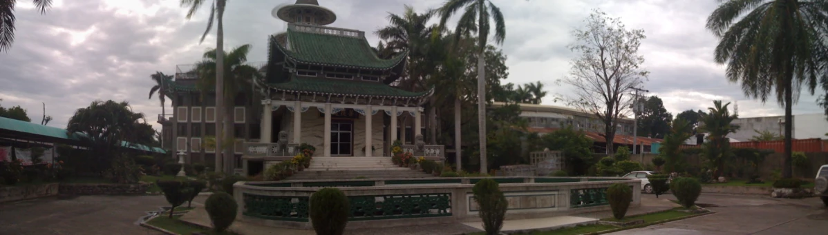 the front yard of a beautiful old building with plants growing on it