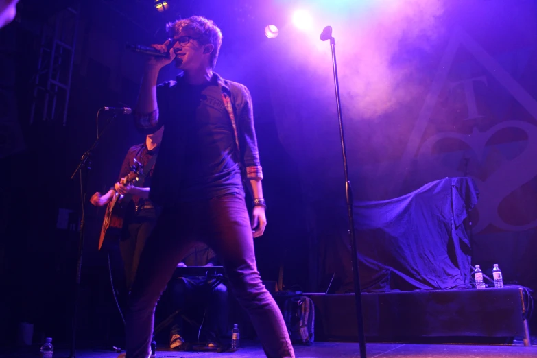 an image of a man singing on stage at night