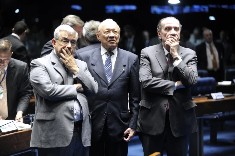 a group of men standing next to each other in front of a row of seats