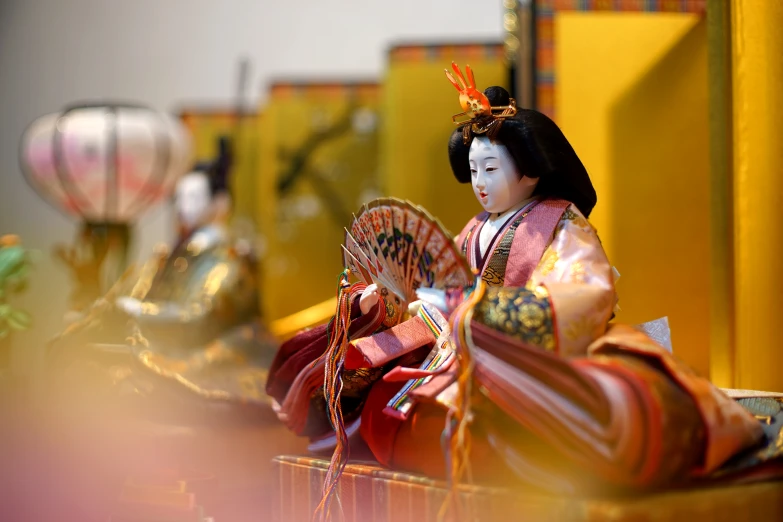 a doll in a geisha garb standing next to other items