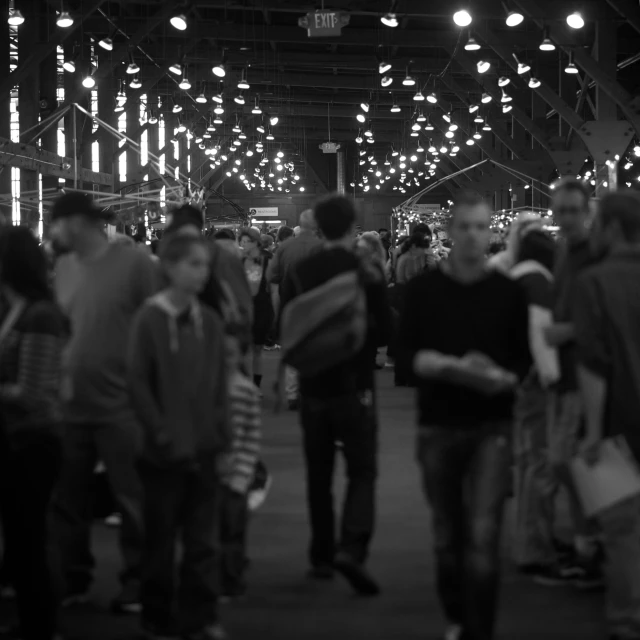 many people walking around in a large, dark room