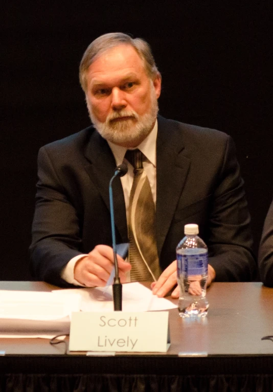 man in business attire sitting at a table